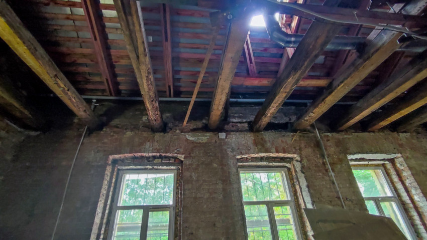 Деревянные балки и кирпичная стена при реконструкции помещения