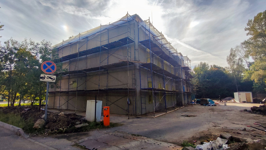 Дом в строительных лесах с дорожным знаком «Остановка запрещена»