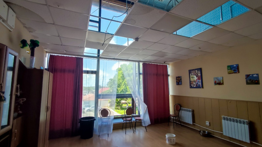 Поврежденный потолок с потеками и открытыми плитами в помещении