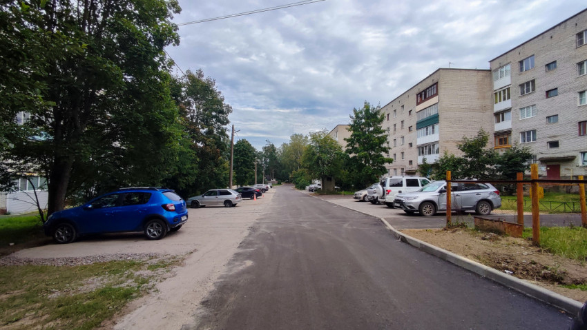 Асфальтированная дворовая дорога с припаркованными автомобилями