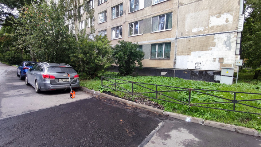 Двор многоквартирного дома с автомобилями и зеленью