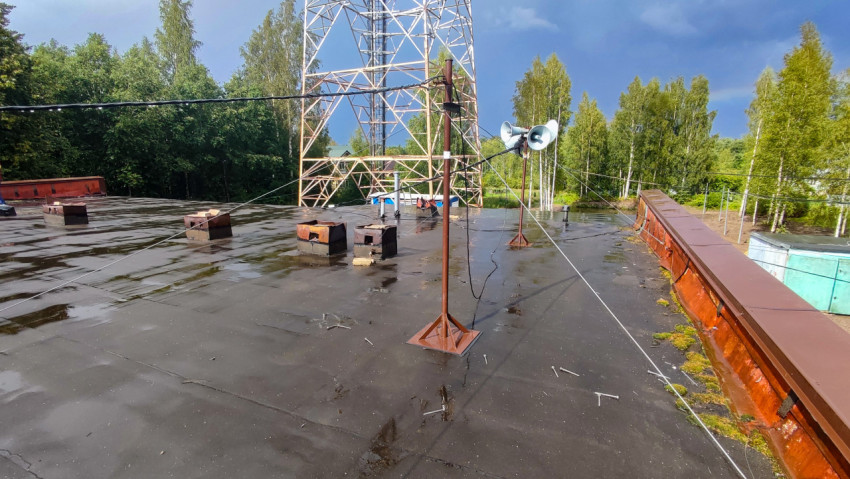 Плоская крыша здания с антеннами и проводами