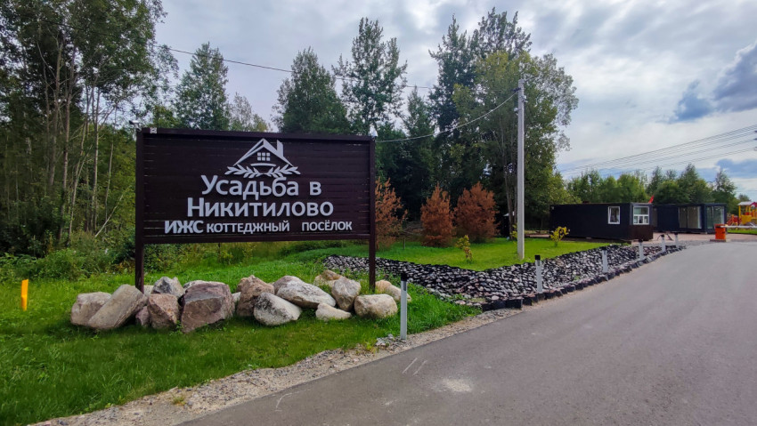 Въезд в коттеджный поселок с информационным щитом