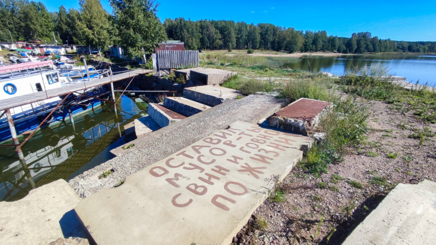 Береговая зона с лодками и надписью на плите