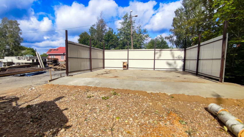 Строительная площадка с металлическим ограждением и бетонным основанием