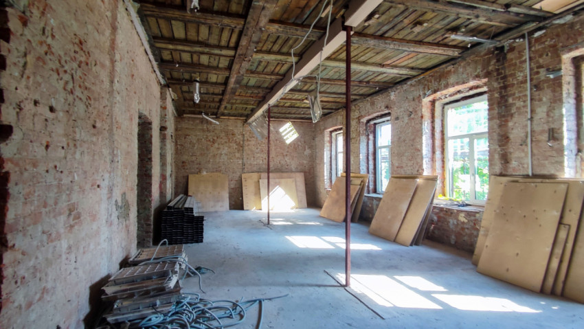 Помещение с кирпичными стенами и деревянным потолком