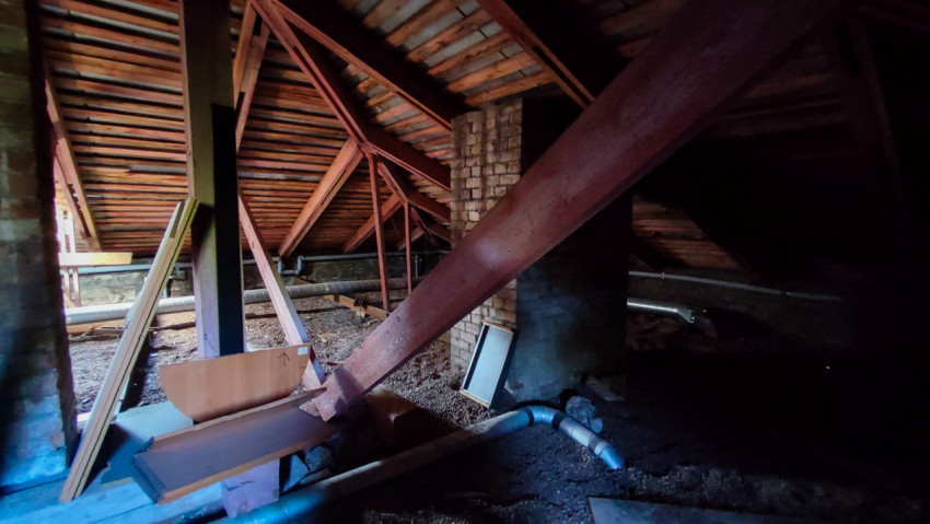 Чердак здания с деревянными балками и кирпичными опорами