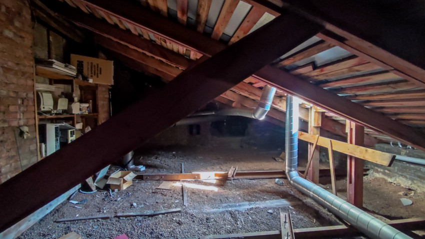 Чердак с деревянными стропилами и металлическими трубами