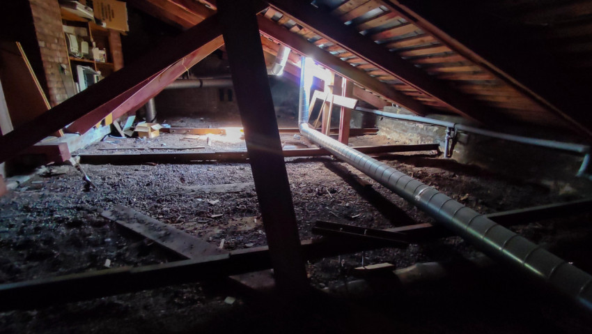 Чердак здания с вентиляционными трубами и старой мебелью