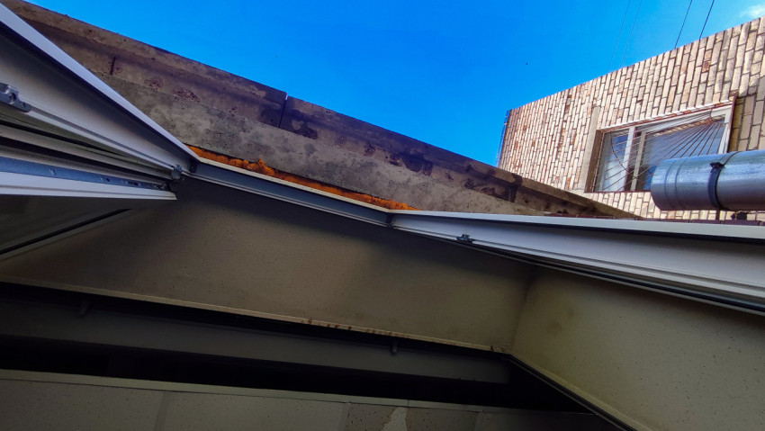 Вид на кровлю здания и открытые стыки плит перекрытия