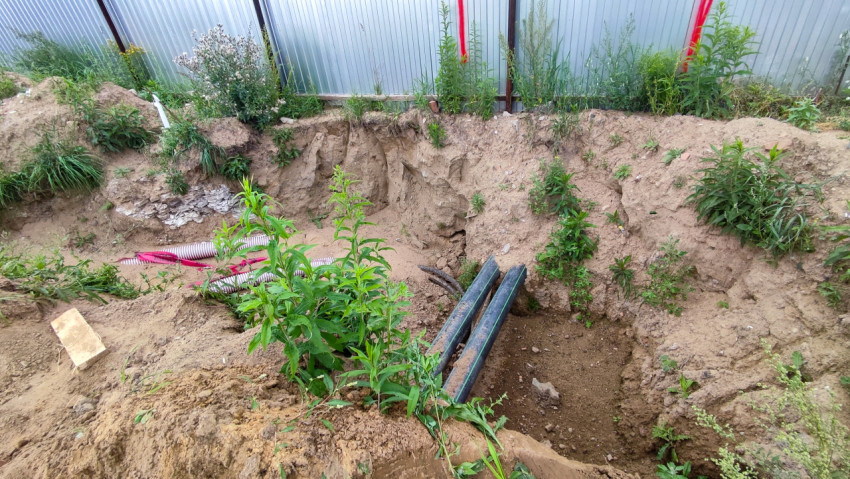 Траншея с кабелями и трубами на участке стройки