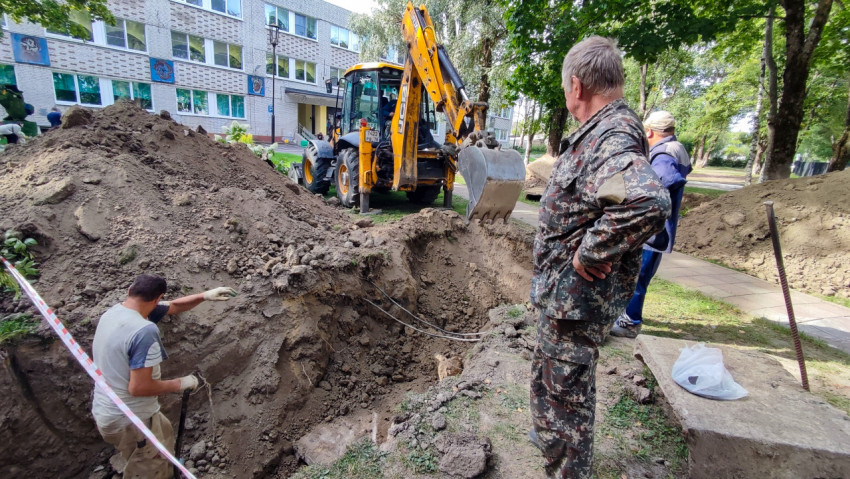 Земляные работы с использованием экскаватора у здания