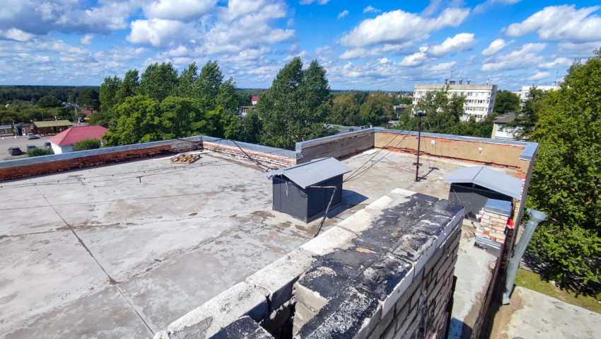 Вид на плоскую крышу здания с инженерными конструкциями