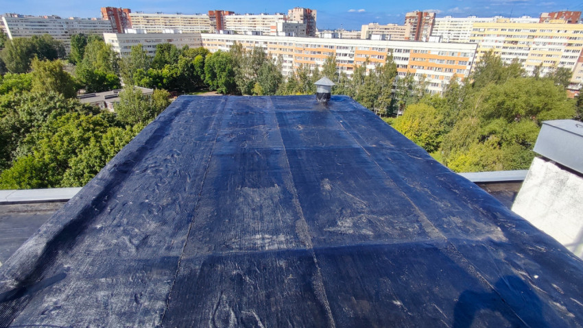 Крыша дома с новым рулонным покрытием