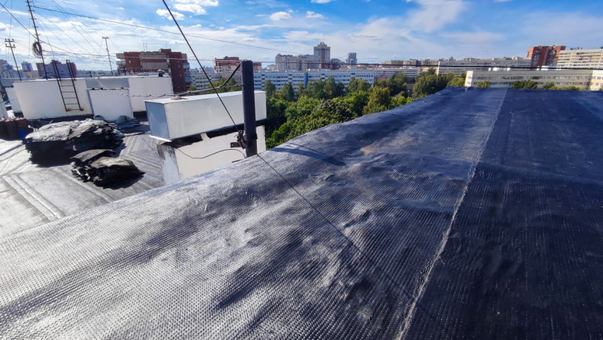 Крыша жилого дома с рулонным покрытием и строительными отходами