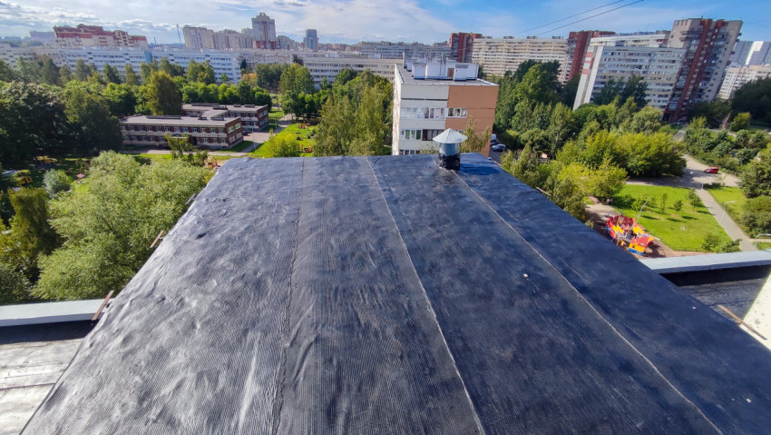 Плоская крыша жилого дома после ремонта рулонным материалом