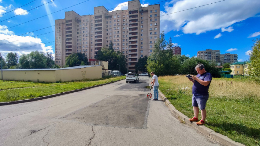 Замеры дорожного полотна на асфальтовом участке во дворе