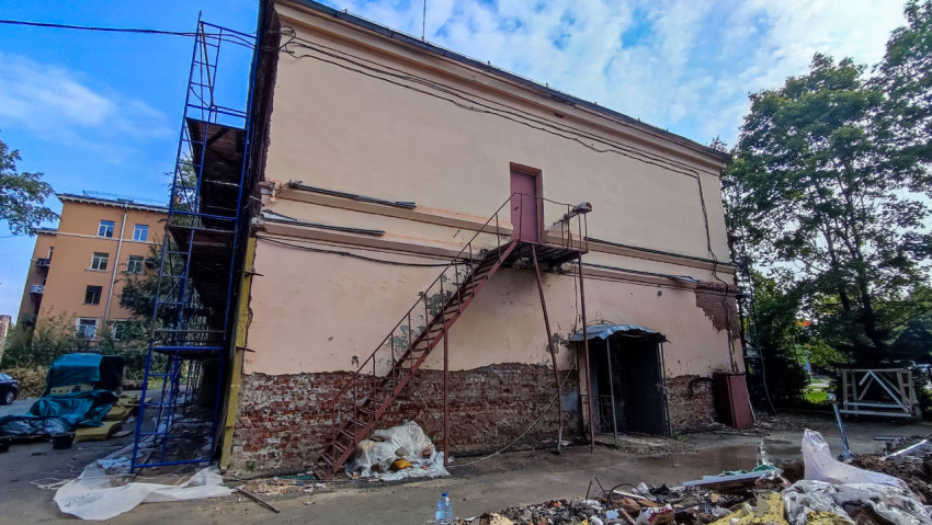 Кирпичное здание с металлической лестницей во время ремонта