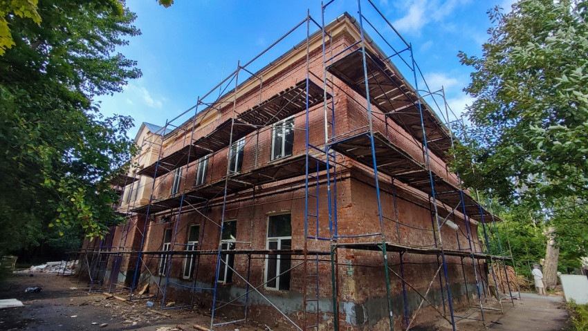 Кирпичное здание в строительных лесах во время капитального ремонта