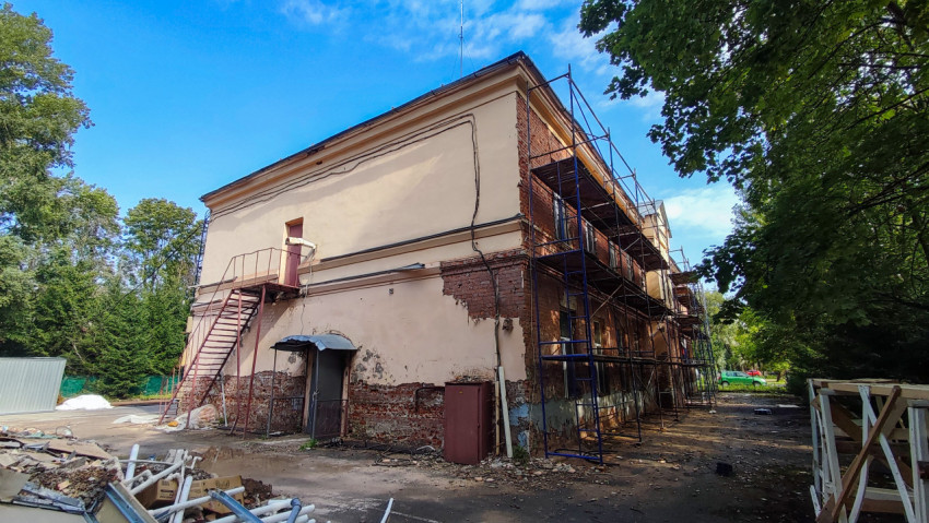 Реконструкция кирпичного здания с лестницей и строительными лесами