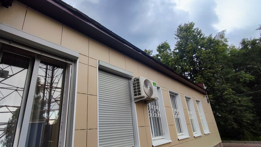 Фасад одноэтажного здания с окнами и кондиционером