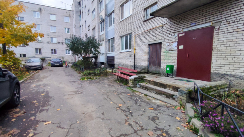 Вход в подъезд жилого дома с лавочкой и урной