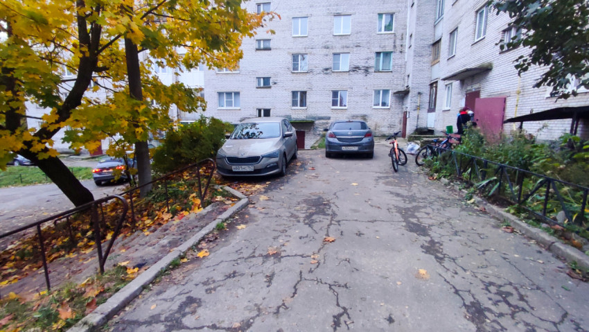 Осенний двор с припаркованными автомобилями и лестницей