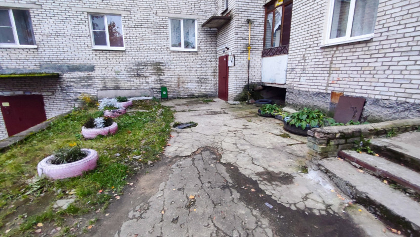 Подъезд жилого дома с цветами в клумбах из автомобильных шин