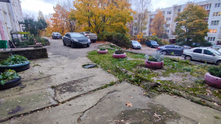 Осенний двор с клумбами из шин и припаркованными автомобилями