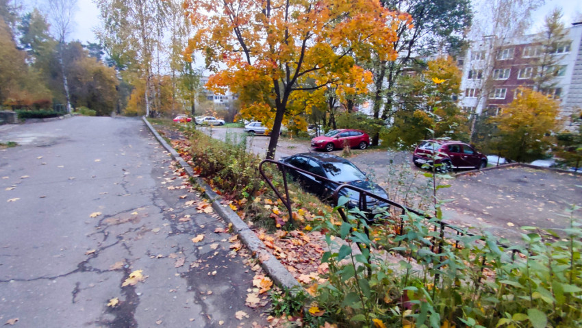 Осенний двор с парковкой у жилого дома