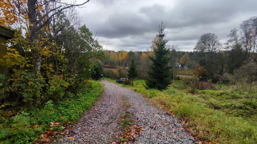 Спуск по гравийной дороге к загородным домам и лесу