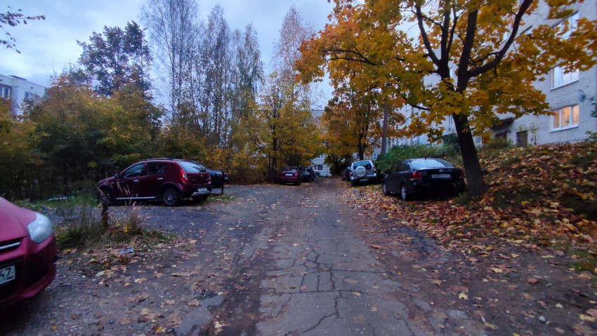 Осенний двор с припаркованными автомобилями у жилого дома