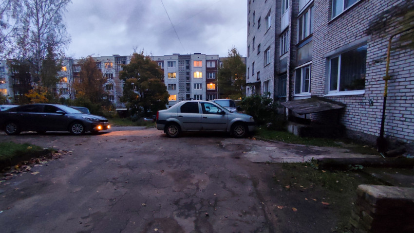 Осенний двор многоквартирного дома с припаркованными автомобилями