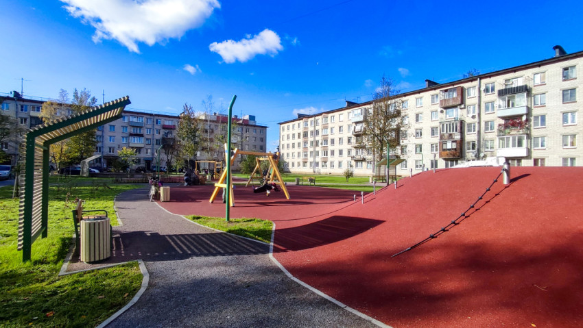 Детская площадка с резиновым покрытием во дворе жилого квартала