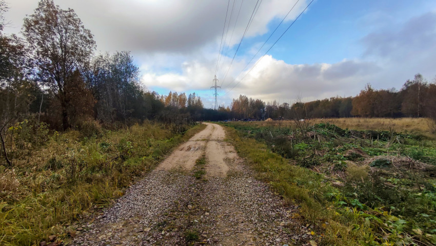 Осенняя дорога к кладбищу вдоль линии электропередачи