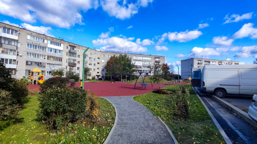 Детская площадка во дворе пятиэтажек с резиновым покрытием