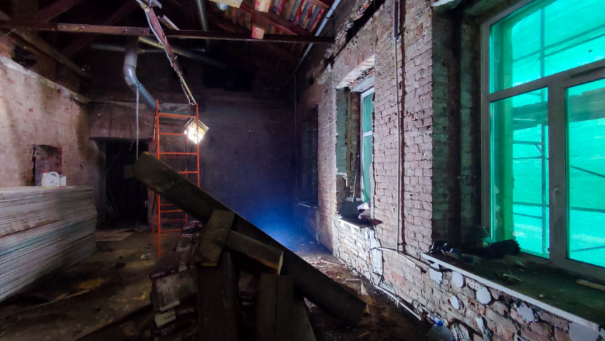 Ремонт помещения с открытыми стропильными балками и строительными материалами