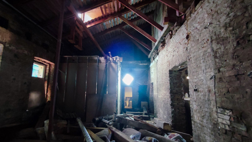 Коридор старого здания на стадии реконструкции с частично разобранной кровлей