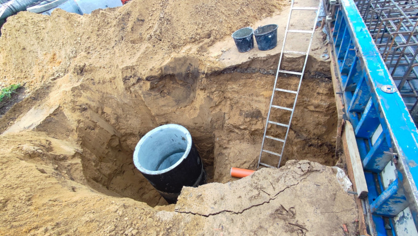 Котлован с установленным колодцем и опалубкой фундамента