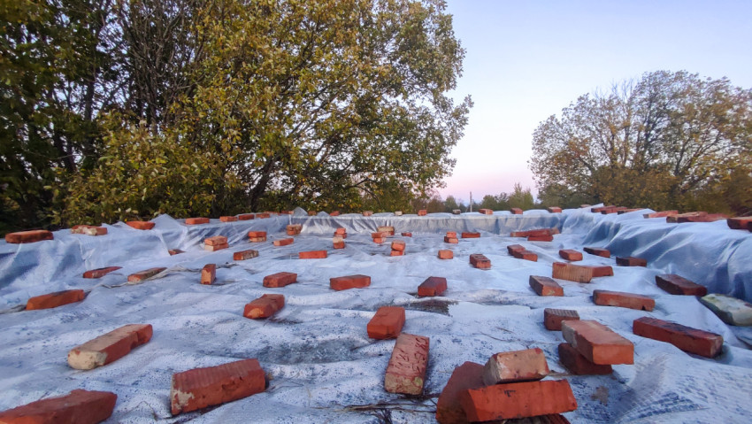 Поверхность укрытого здания с кирпичами, уложенными на защитную плёнку