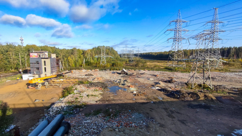 Высоковольтные линии и строительная техника на фоне леса