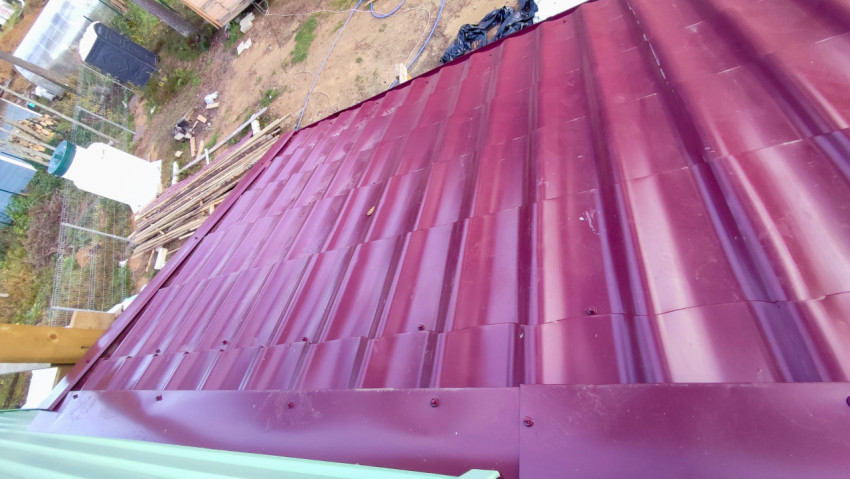 Металлочерепица бордового цвета на скате крыши частного дома