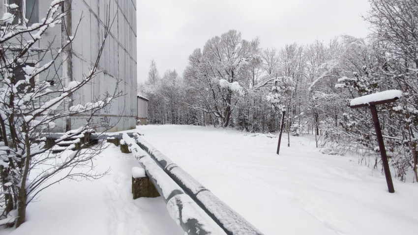Задворки жилого дома с опорами трубопровода в зимний период