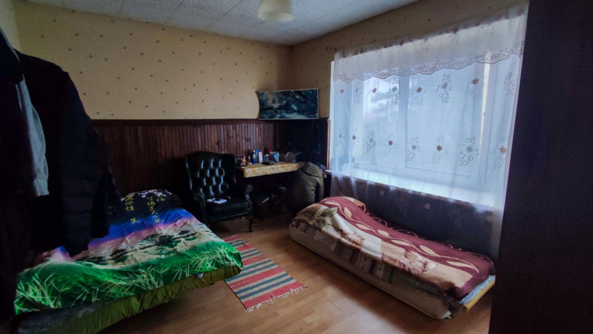 Жилая комната с двумя кроватями и рабочим столом у окна