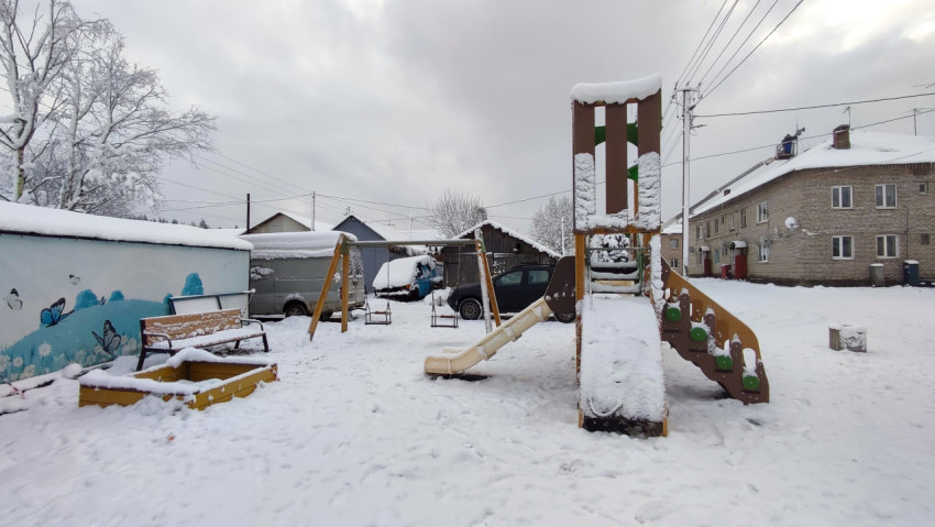 Детская игровая площадка во дворе жилого дома зимой