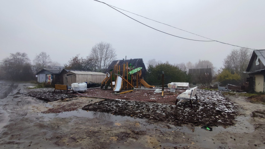 Новая детская площадка во дворе частного сектора в осенний день