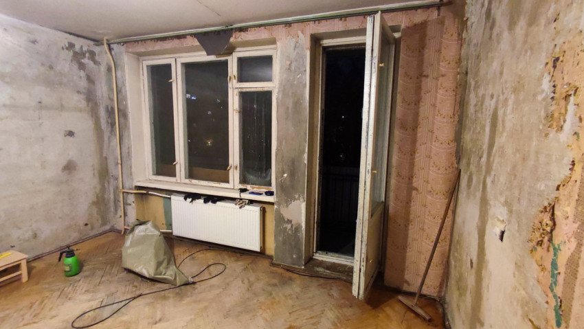 Комната с окном и балконной дверью на этапе ремонта
