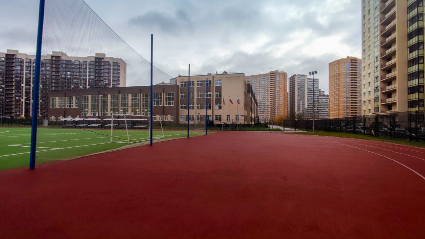 Спортивная площадка у школьного здания среди жилых домов