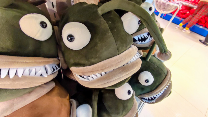 Плюшевые рыбы-удильщики на выставочной полке магазина