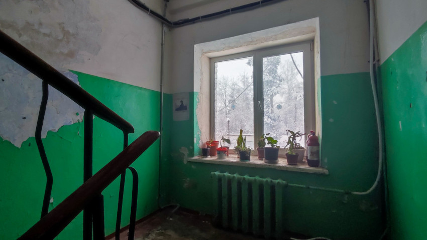 Лестничная площадка с окном и радиатором отопления